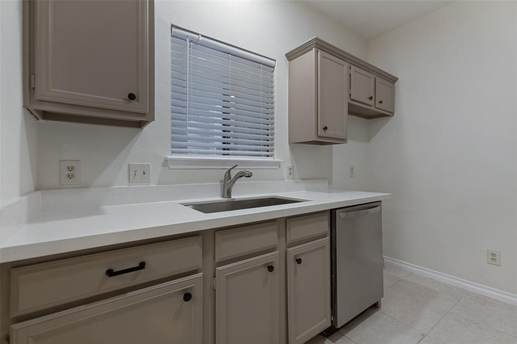 5550 Spring Valley Road, Unit C16 Dallas, TX 75254 - Photo 17 of 22 Kitchenette featuring neutral-toned cabinetry, a stainless steel sink, a stainless steel dishwasher, white countertops, and tile flooring