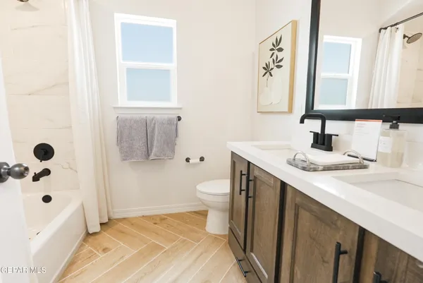 a bathroom with a sink a toilet and shower curtain