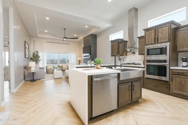 a kitchen with stainless steel appliances kitchen island granite countertop a stove and a sink