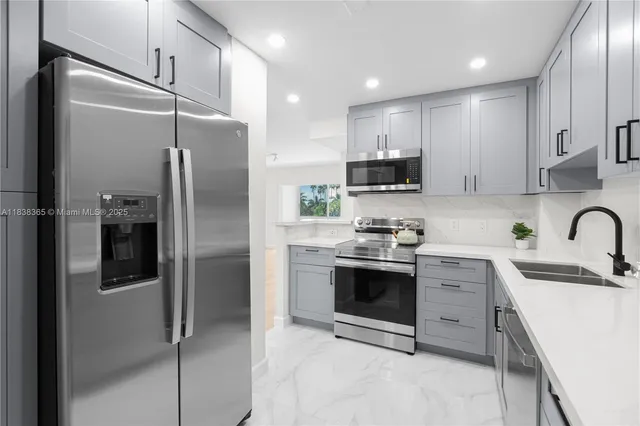 a kitchen with stainless steel appliances granite countertop a refrigerator sink and stove