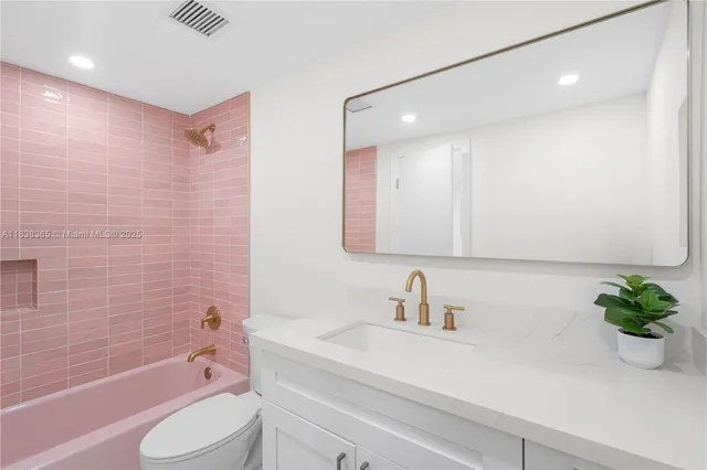 a bathroom with a sink a toilet a tub and shower