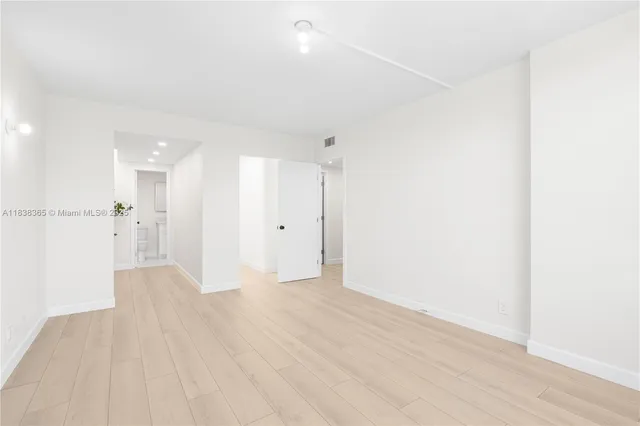 a view of a big room with wooden floor and a bathroom