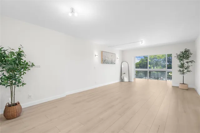 a view of an empty room with a window and a potted plant