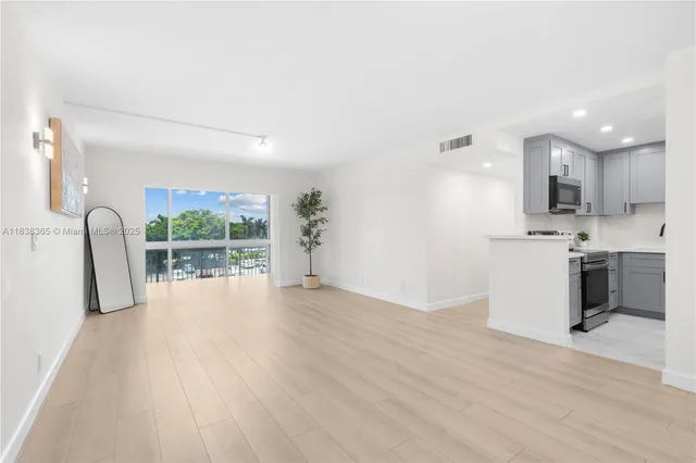 a view of a kitchen with a sink and dishwasher a refrigerator with wooden floor