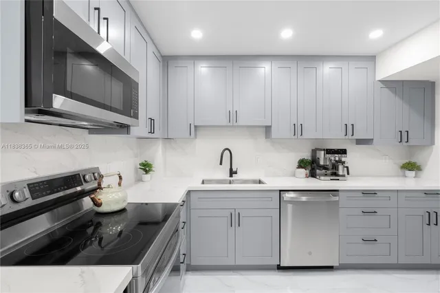 a kitchen with stainless steel appliances granite countertop a sink stove and microwave