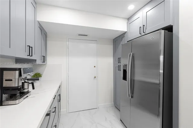 a kitchen with a refrigerator a sink and cabinets