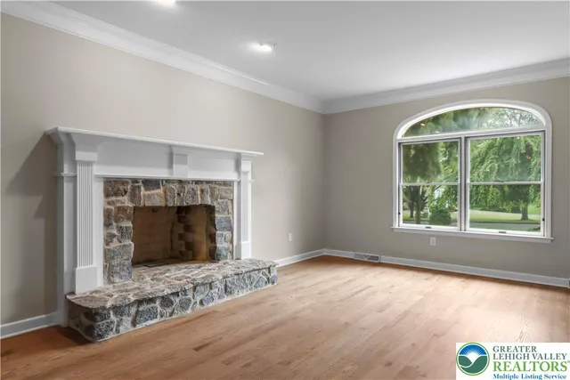 an empty room with windows and fireplace