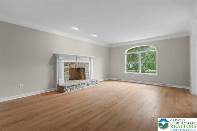 an empty room with a fireplace and wooden floor