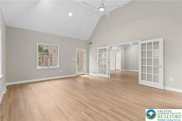 an empty room with wooden floor and windows