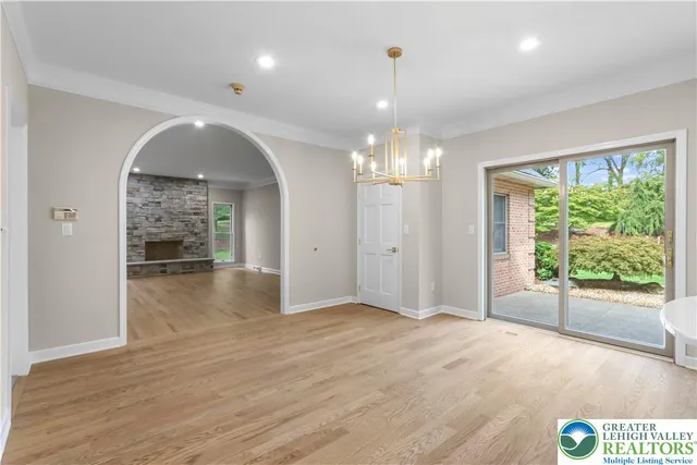a view of a hallway with wooden floor and chandelier