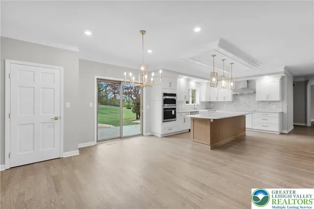 a view of kitchen with kitchen island wooden floor and stainless steel appliances