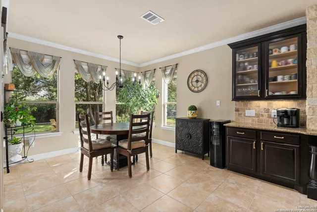 a view of hallway with a chair and frames on wall