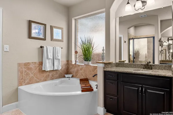 a bathroom with a sink a toilet a mirror and shower