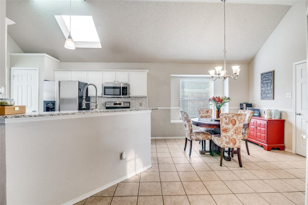4201 Crystal Lane Garland, TX 75043 - Photo 15 of 33 a kitchen with stainless steel appliances granite countertop a sink a stove a dining table and chairs