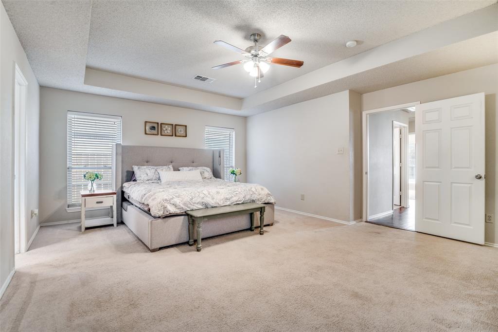 4201 Crystal Lane Garland, TX 75043 - Photo 19 of 33 a spacious bedroom with a bed and a chandelier