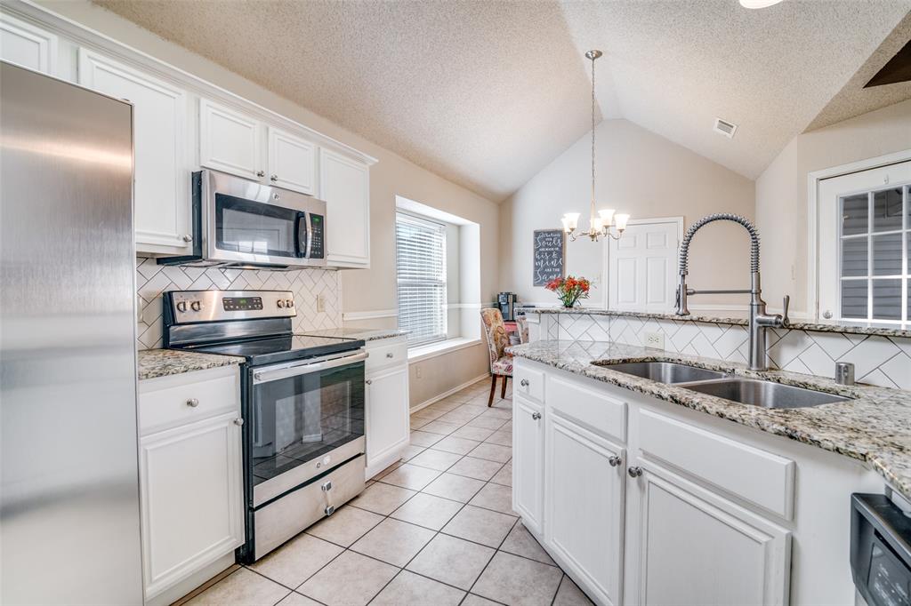 4201 Crystal Lane Garland, TX 75043 - Photo 3 of 33 a kitchen with granite countertop a sink stainless steel appliances and white cabinets