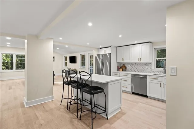 a kitchen with stainless steel appliances granite countertop a stove a sink a refrigerator and a microwave