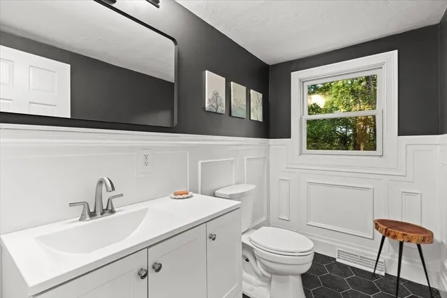 a bathroom with a sink a toilet and a mirror