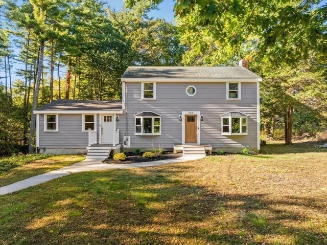 a view of a yard in front of a house with a large tree