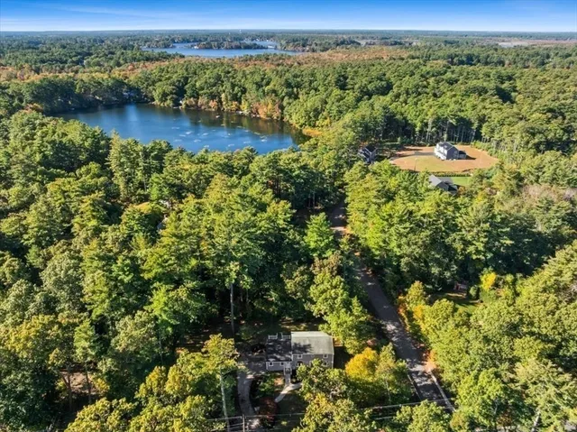 an aerial view of residential houses with outdoor space and trees