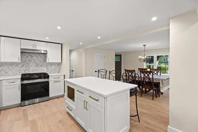 a kitchen with stainless steel appliances kitchen island granite countertop a stove and a refrigerator