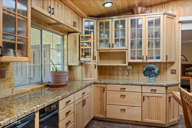 a kitchen with granite countertop a sink and cabinets