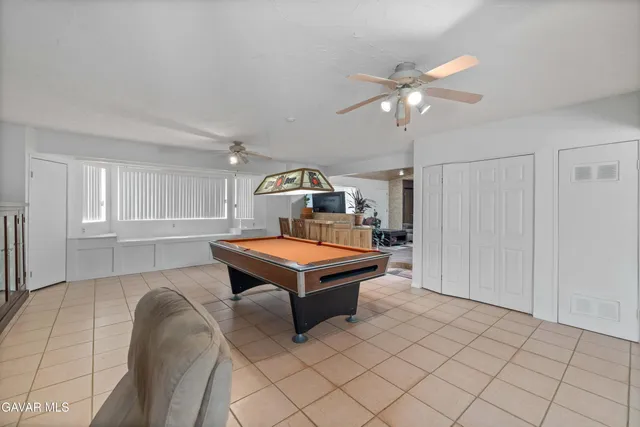 a room with pool table and windows