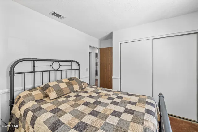 a bed sitting in a bedroom next to a window