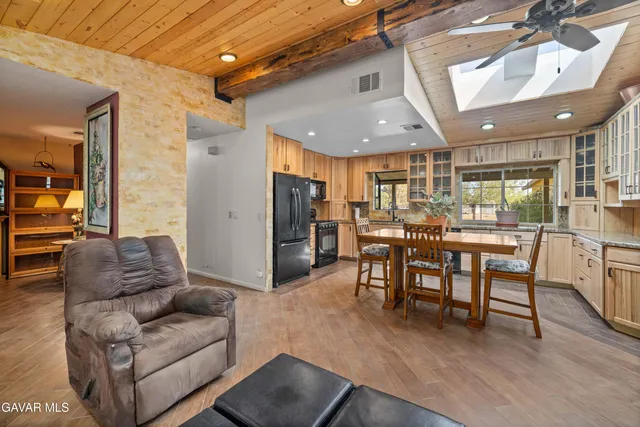a living room with furniture kitchen and a wooden floor