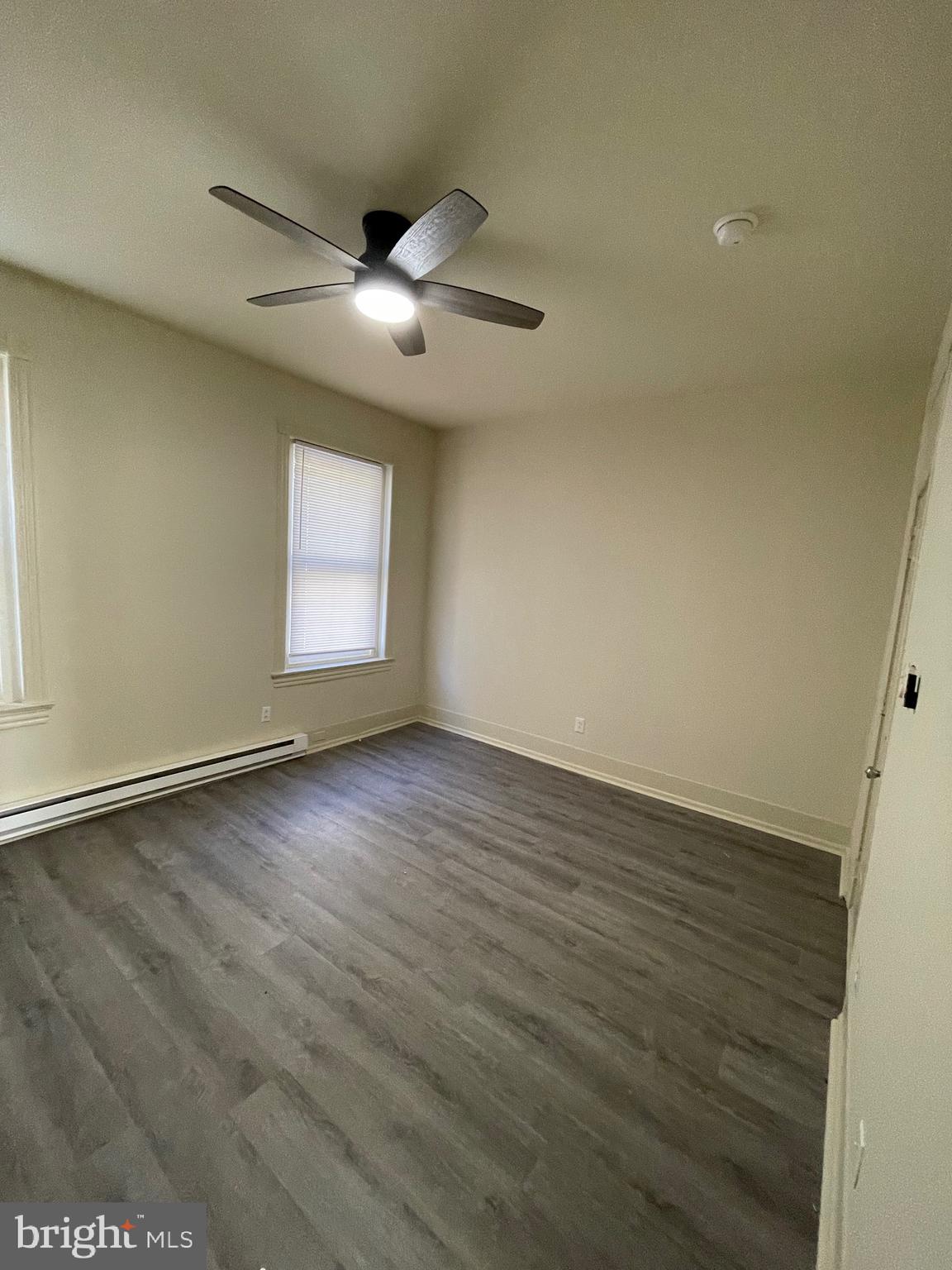 5122 Arch Street, Unit 2 Philadelphia, PA 19139 - Photo 2 of 9 an empty room with wooden floor and windows