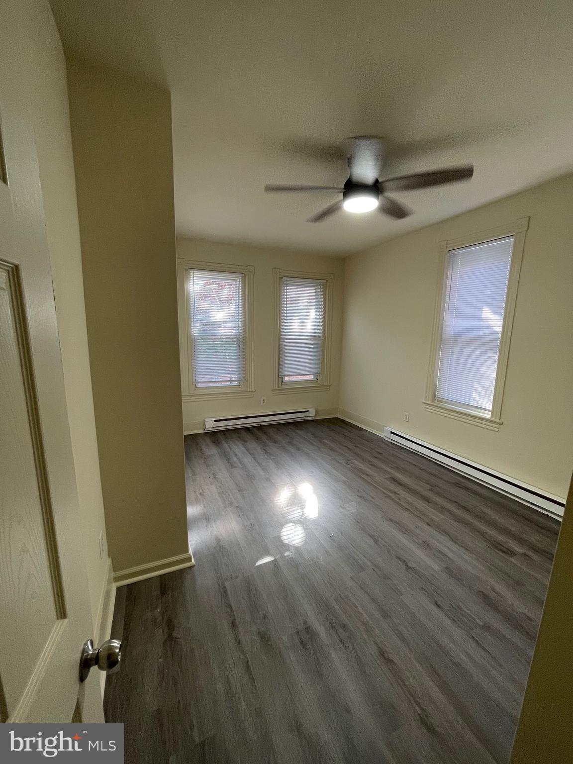 5122 Arch Street, Unit 2 Philadelphia, PA 19139 - Photo 8 of 9 an empty room with wooden floor and windows