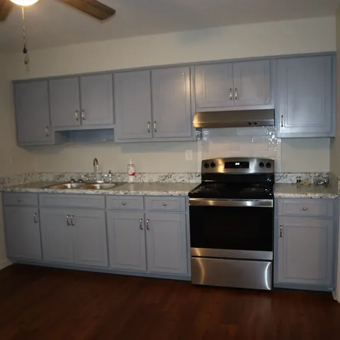 a kitchen with granite countertop white cabinets and appliances