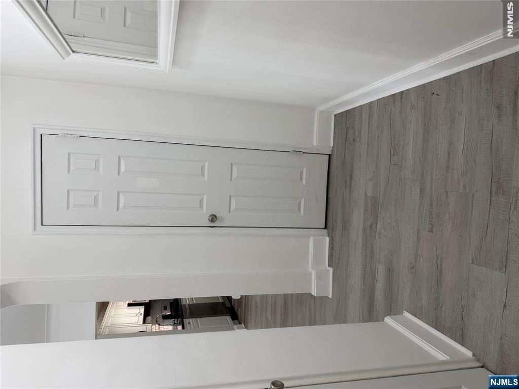 100 Prospect Avenue, Unit 2E Hackensack, NJ 07601 - Photo 3 of 16 a view of empty room with wooden floor and cabinet