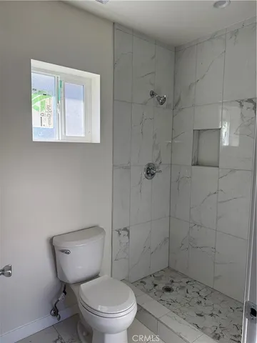 a white toilet sitting next to a shower