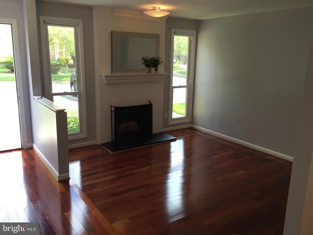 9042 Saffron Lane Silver Spring, MD 20901 - Photo 3 of 21 a living room with wooden floors and a fireplace
