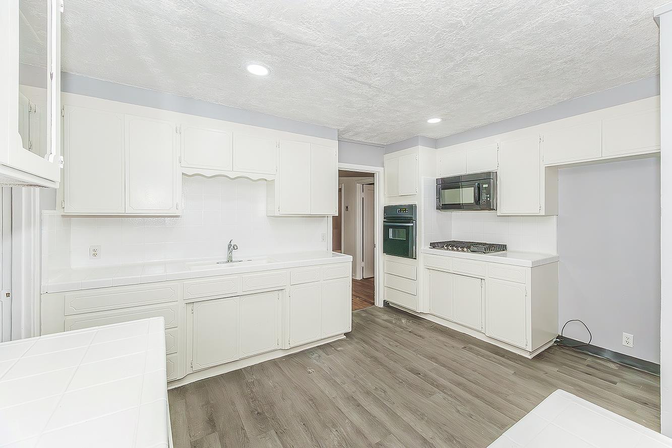 422 North Pine Street Madera, CA 93637 - Photo 13 of 54 a kitchen with a sink a stove cabinets and a refrigerator