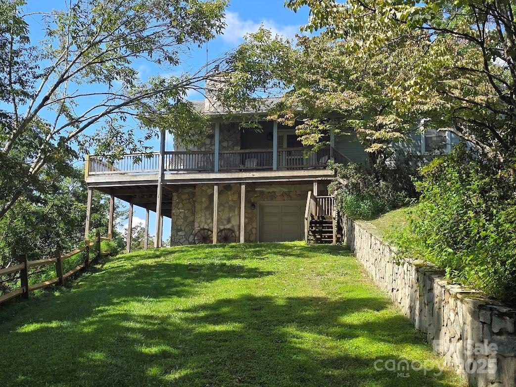 a view of a backyard with table and chairs and large trees