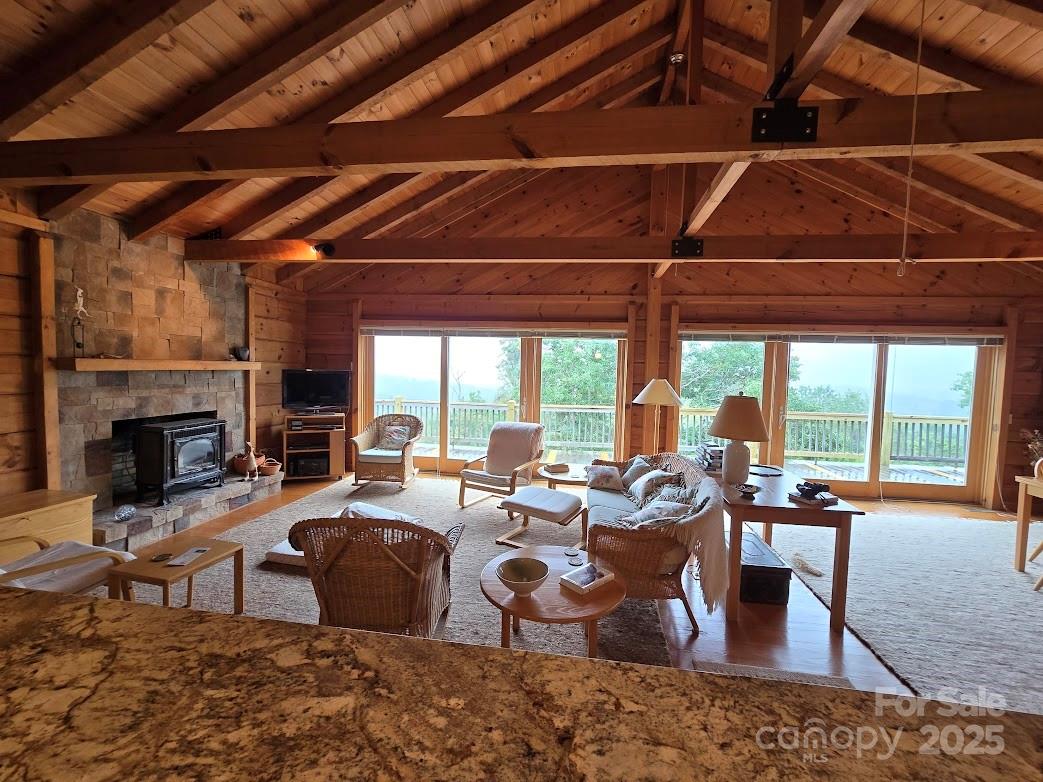 979 Wagon Road, Unit 68 Warrensville, NC 28693 - Photo 31 of 40 a living room with furniture a fireplace and a floor to ceiling window