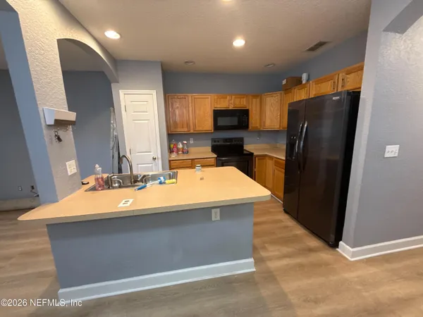 a room with a refrigerator a sink and cabinets