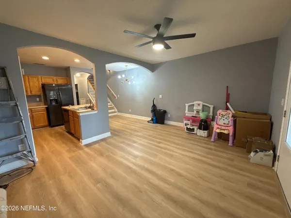 a view of a livingroom with furniture a ceiling fan and wooden floor
