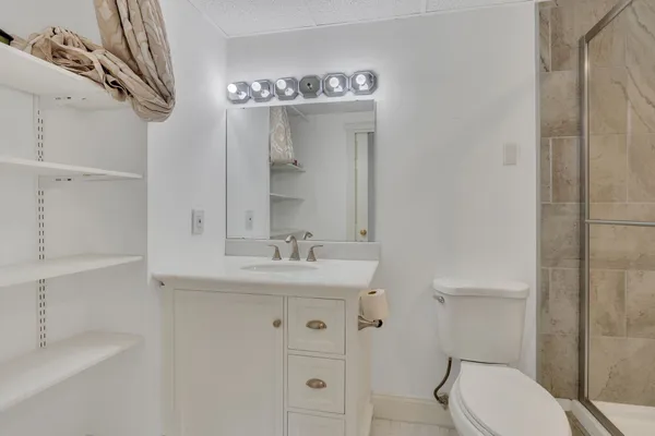 a bathroom with a granite countertop toilet sink and mirror