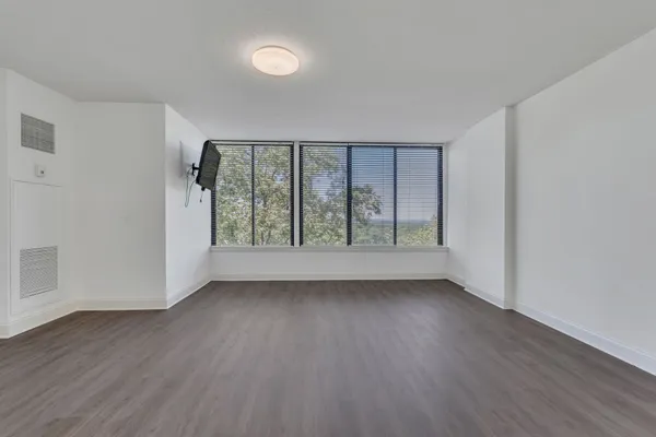 a view of an empty room with wooden floor