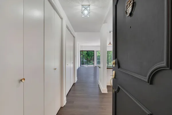 a kitchen with granite countertop a stove a sink a refrigerator and white cabinets with wooden floor