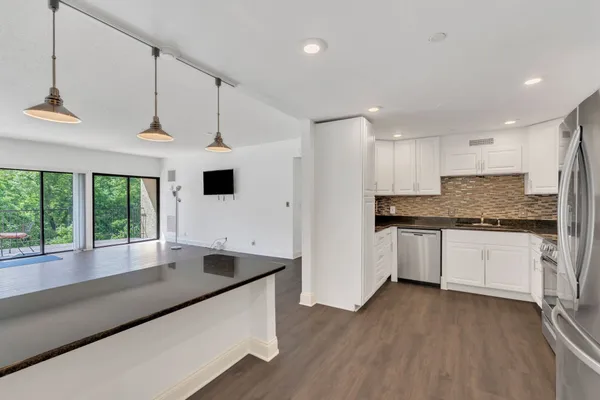 a kitchen with stainless steel appliances granite countertop a refrigerator and a stove top oven