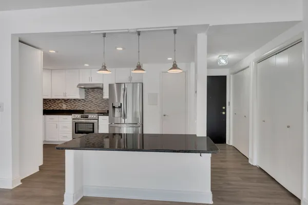 a kitchen with stainless steel appliances granite countertop a refrigerator a sink and a stove