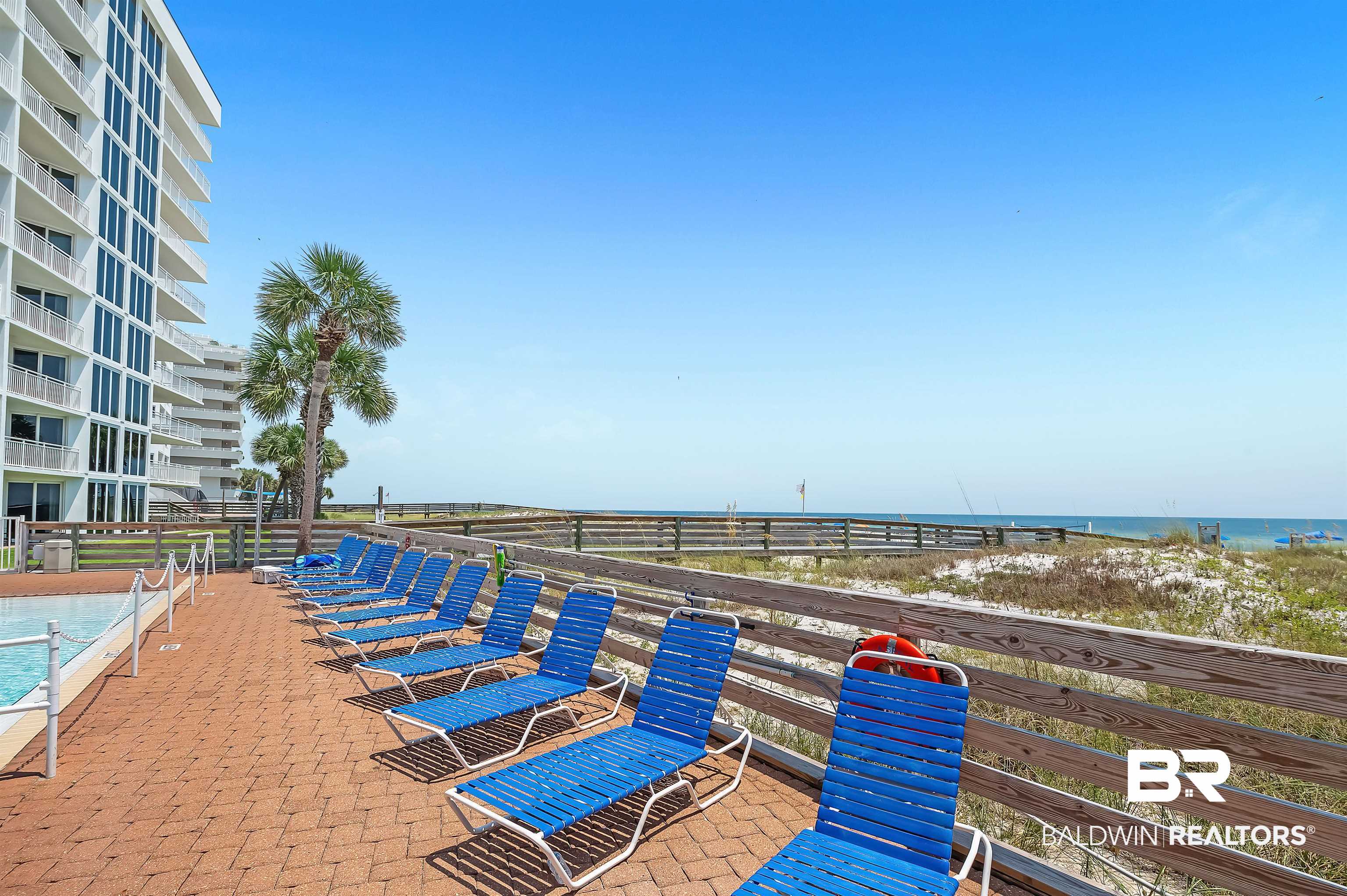 16287 Perdido Key Drive, Unit 105 Pensacola, FL 32507 - Photo 43 of 66 Outdoor amenity area featuring a brick paver deck, a swimming pool, and a wooden boardwalk leading to the sandy beach