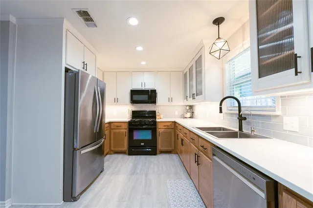 a kitchen with stainless steel appliances a refrigerator sink and cabinets
