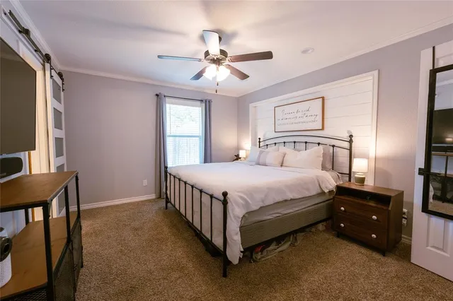 a bed room with a bed and a flat tv screen