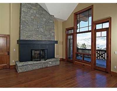 a living room with a fireplace and a floor to ceiling window