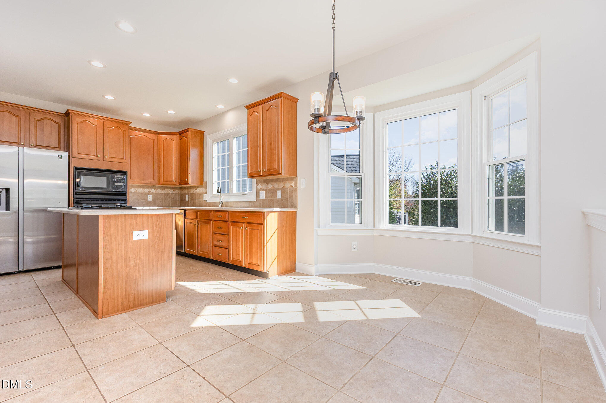 9113 Mission Hills Court Raleigh, NC 27617 - Photo 11 of 36 a kitchen with stainless steel appliances granite countertop a stove top oven a sink a counter top space cabinets and a window